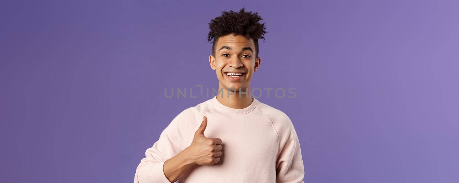 Close-up portrait of satisfied young smiling man recommend something really good, show thumbs-up in approval, like and agree with perfect choice, leave positive feedback, smiling happy.