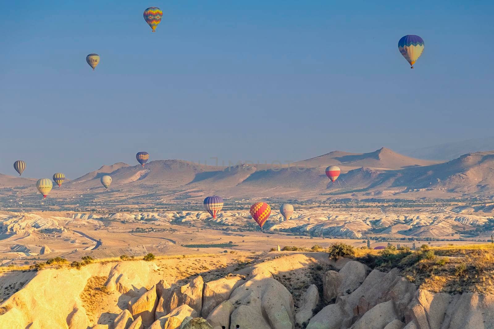 Cappadocia Turkey 08.01.2021 Large colored hot air balloons fly against the backdrop of mountain landscapes at sunrise early in the morning. by Leoschka