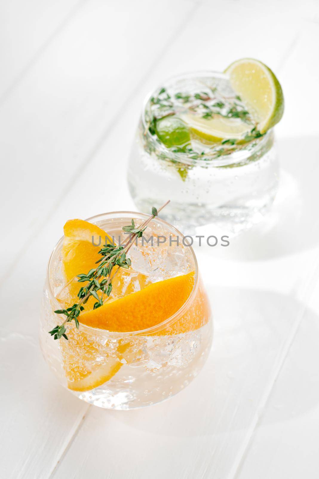 two glasses with an alcoholic cocktail on a light background. hard seltzer is a low-alcoholic drink by gulyaevstudio