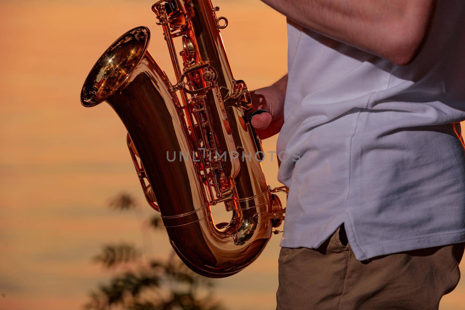 Hands and saxophone close up. The guy plays a wind instrument.