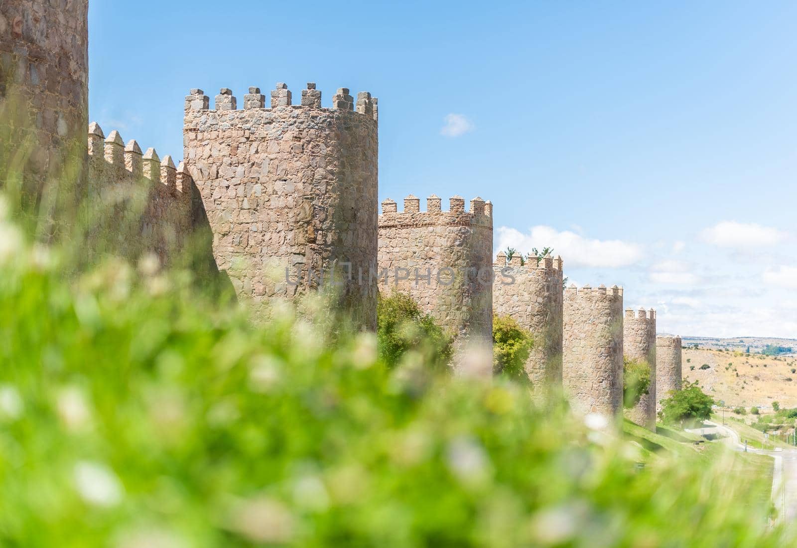 Scenic view of famous Avila Walls with tall towers made of stone located in Spain on sunny day