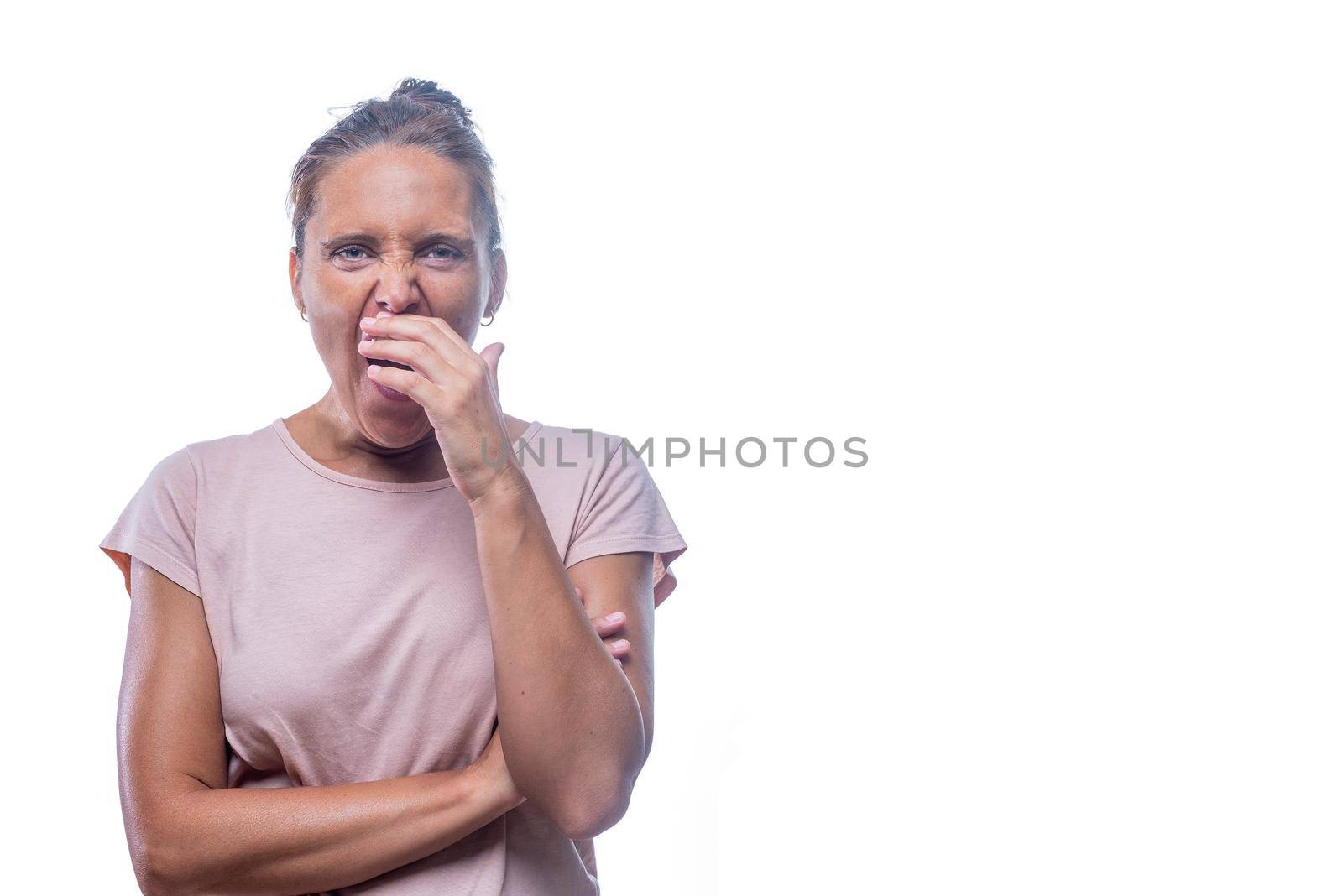 Front view of a green-eyed woman bored and yawning covering mouth with hand on a white background with copy space.