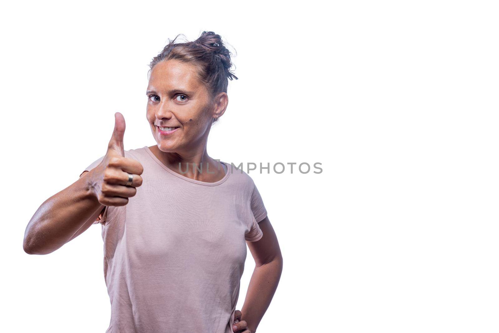 Front view of a positive green-eyed woman showing thumb up on a white background with copy space.