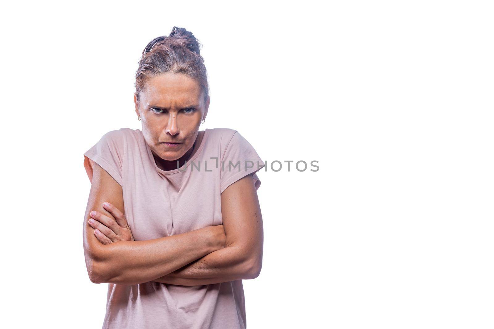 Front view of an abgry green-eyed woman with crossed arms looking at camera on a white background with copy space.