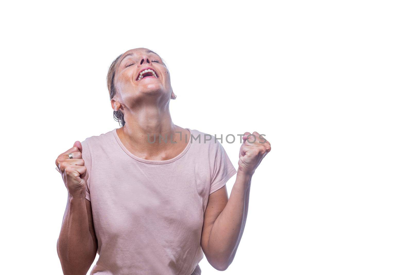 Front view of a grateful or relieved adult woman with clenched fists and head back on a white background with copy space.