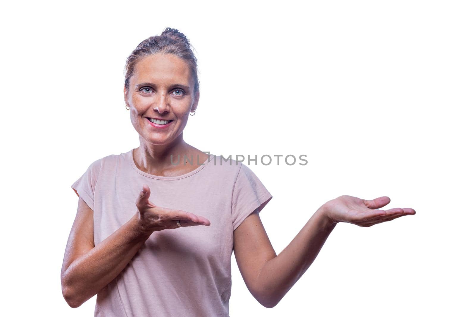 Front view of a smiling green-eyed woman with both palm up showing something looking at camera on a white background with copy space.