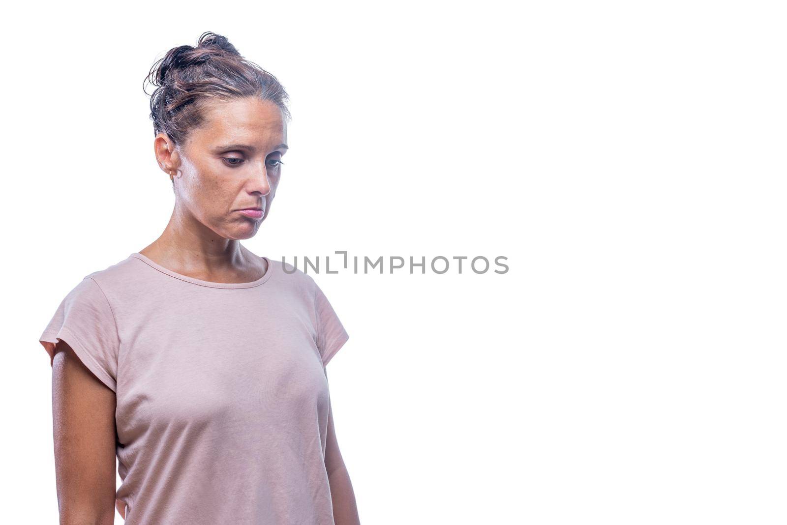 Front view of a sad woman looking down on a white background with copy space.