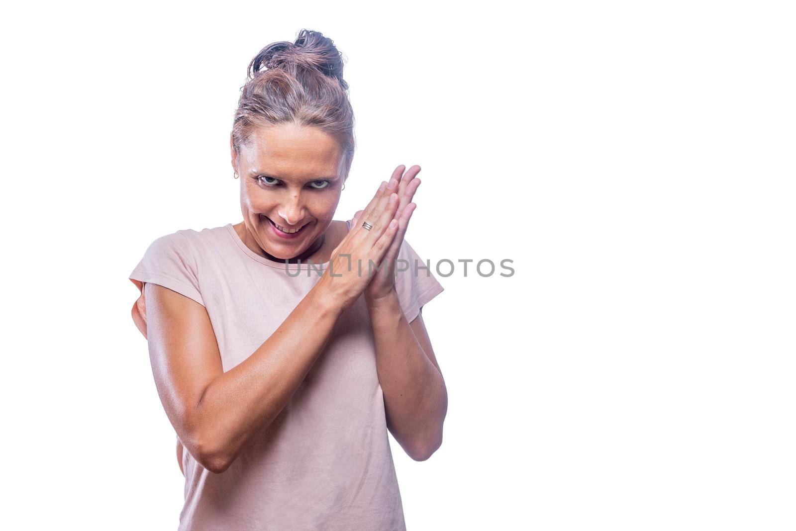 Front view of a green-eyed woman smiling with a malicious laugh looking insane rubbing her hands together on a white background with copy space.