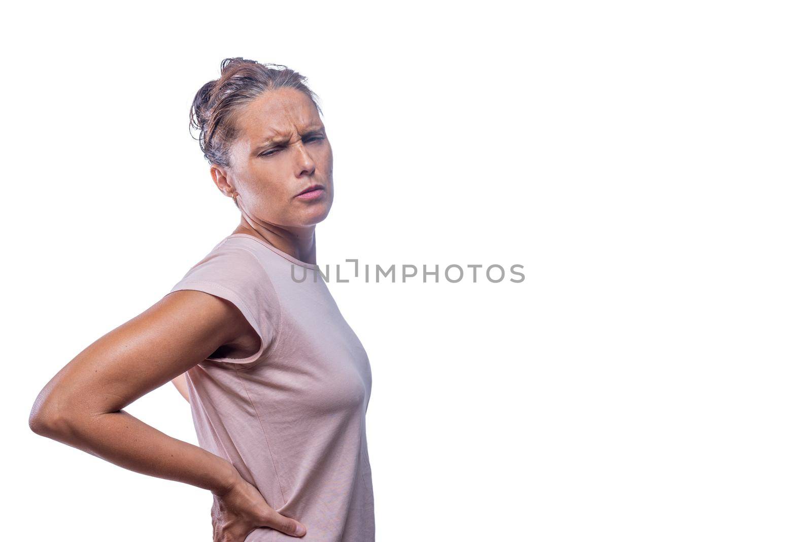 Side view of a woman touching her waist with back pain on a white background with copy space.