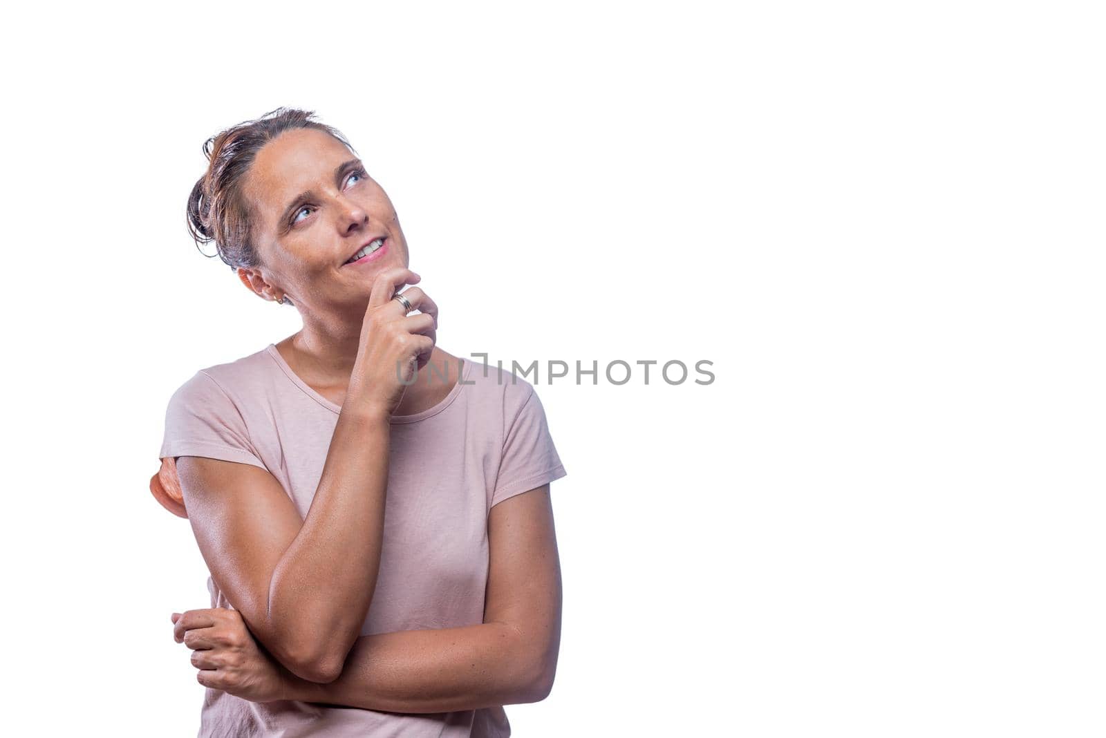 Front view of a dreamy green-eyed woman looking up on a white background with copy space.