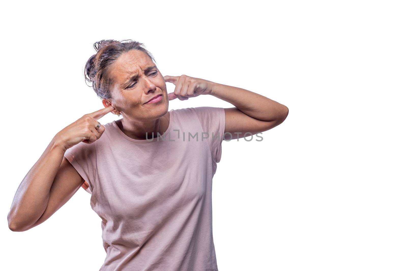 Front view of a woman who covers her ears due to excessive noise on a white background with copy space.
