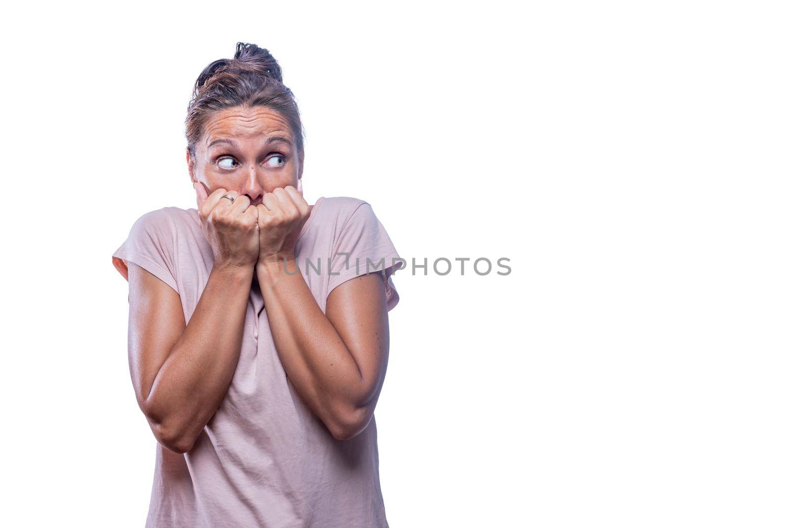 Front view of a green-eyed frightened woman looking to the side on a white background with copy space.