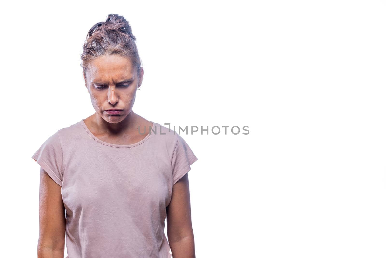 Front view of a concerned woman standing looking down on a white backgound with copy space.