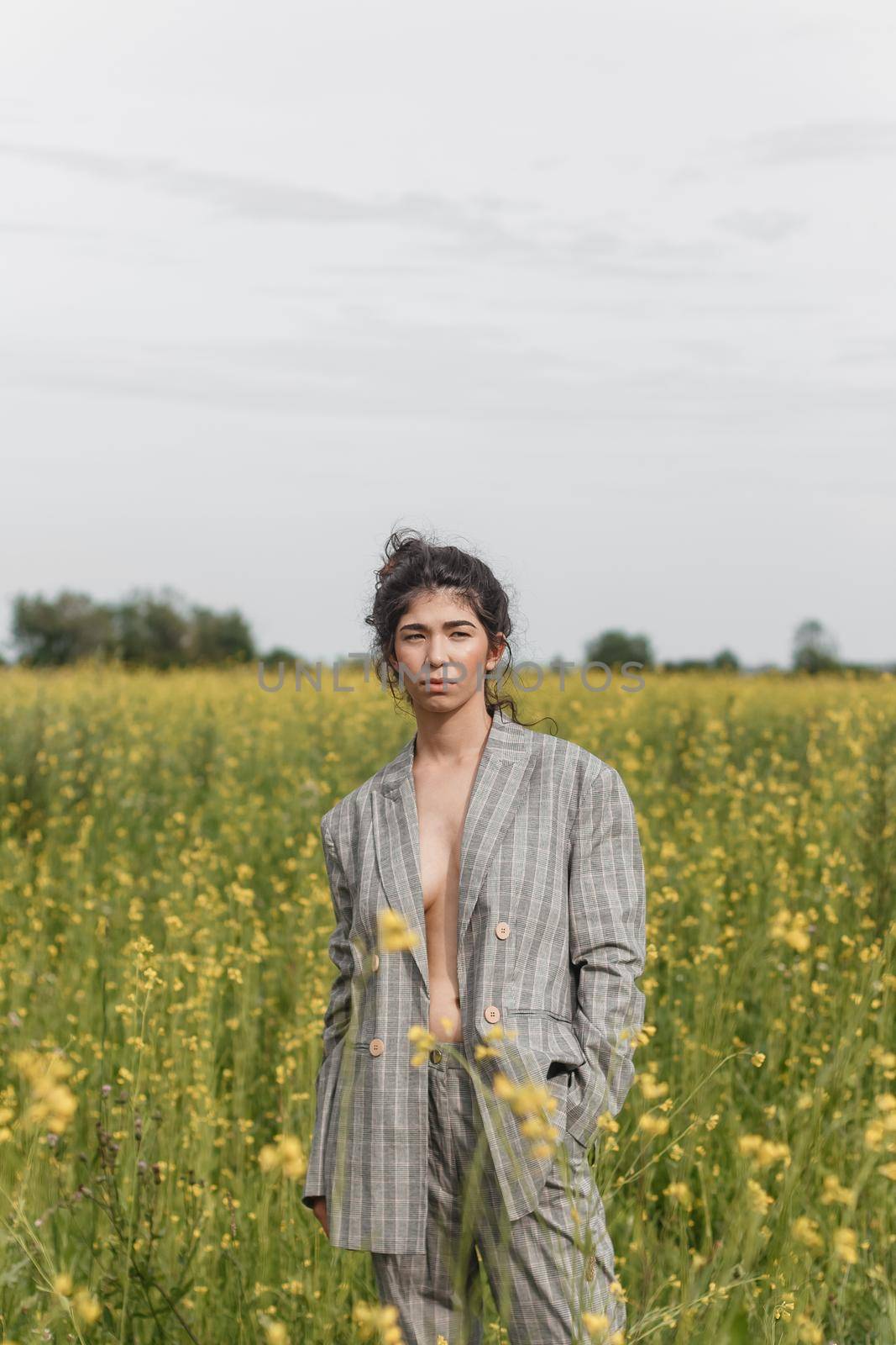 An Asian model poses in a field of yellow flowers for a clothing brand, polyethylene is the main props for a photo shoot. by Annu1tochka