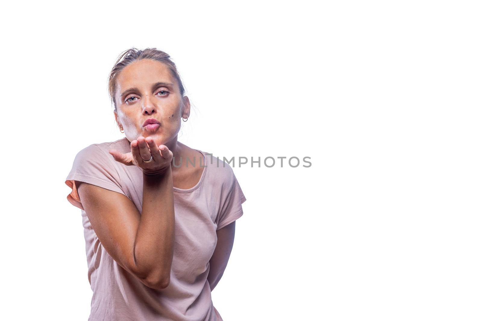 Front view of a green-eyed woman sending air kiss on a white background with copy space.