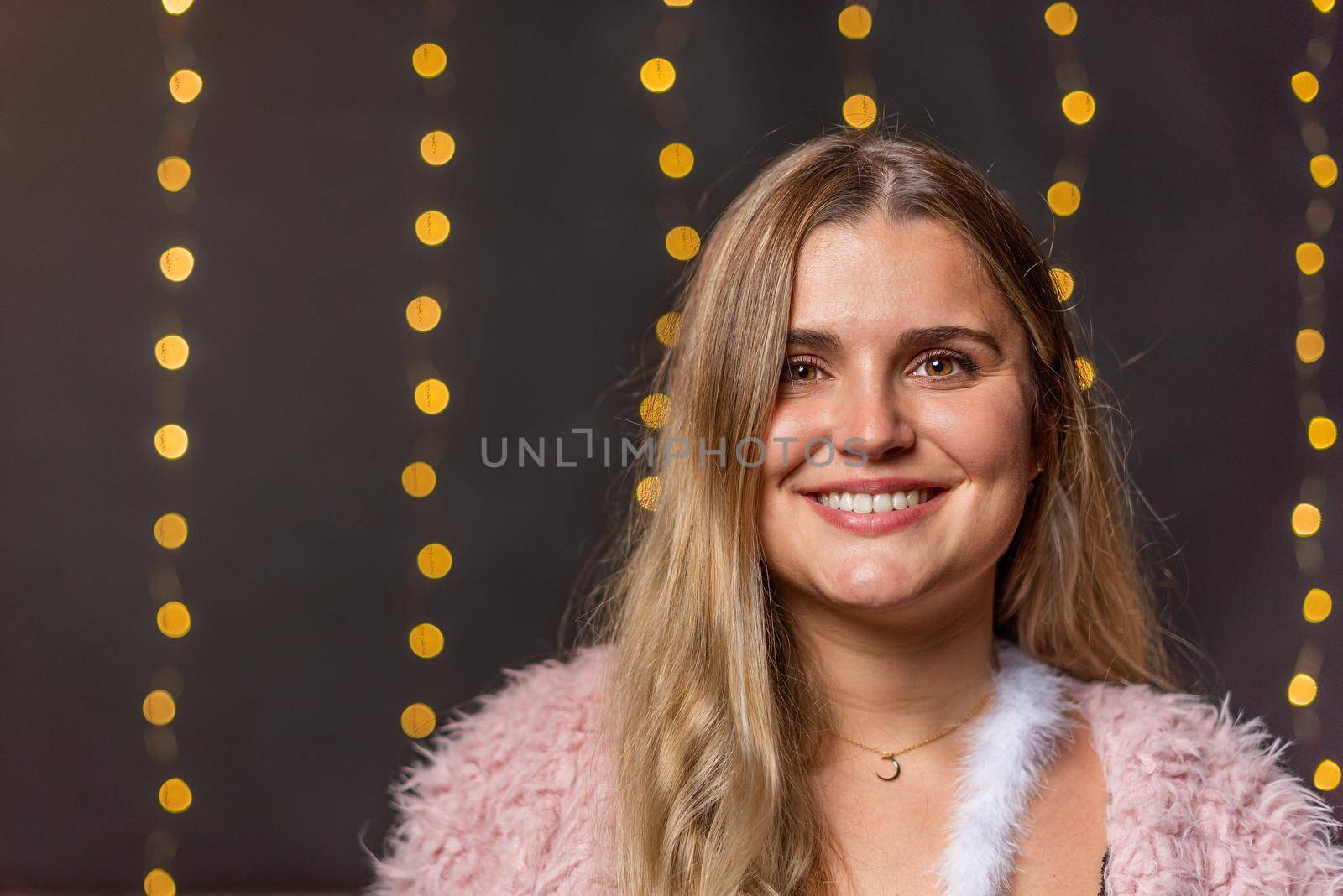 Portrait of a caucasian woman smiling and looking at camera with a blurred light background