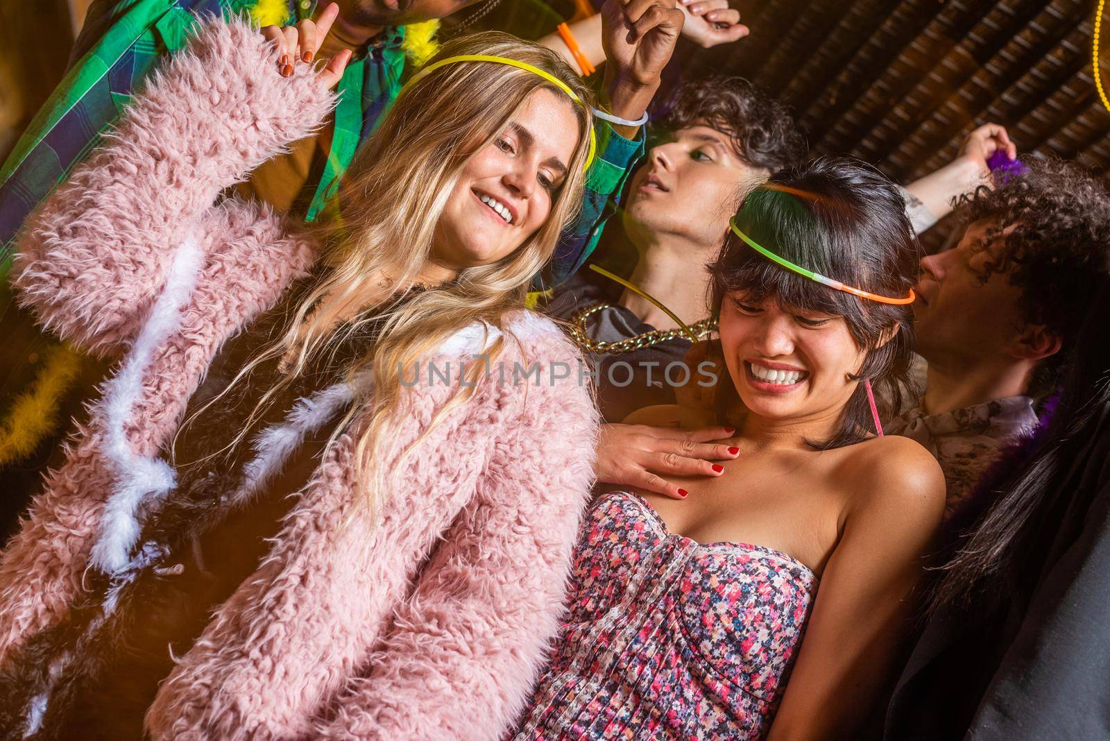 Low angle view of young women having fun with their friends in a party