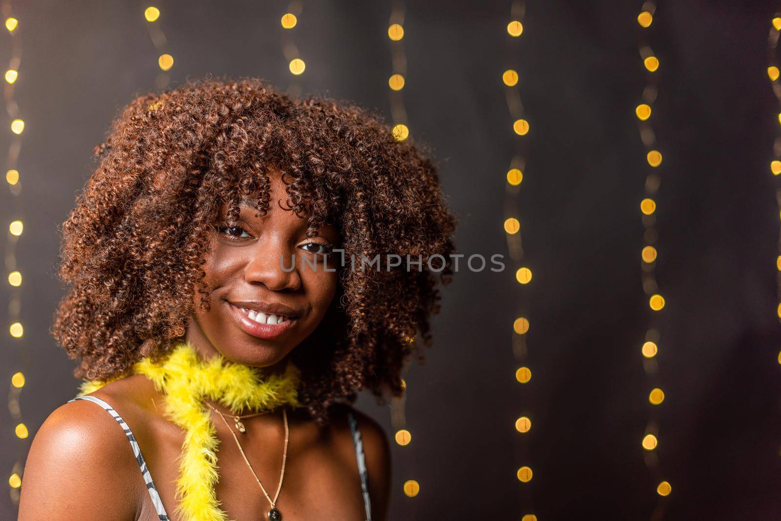 Smiling African American woman with curly hair looking at camera by ivanmoreno