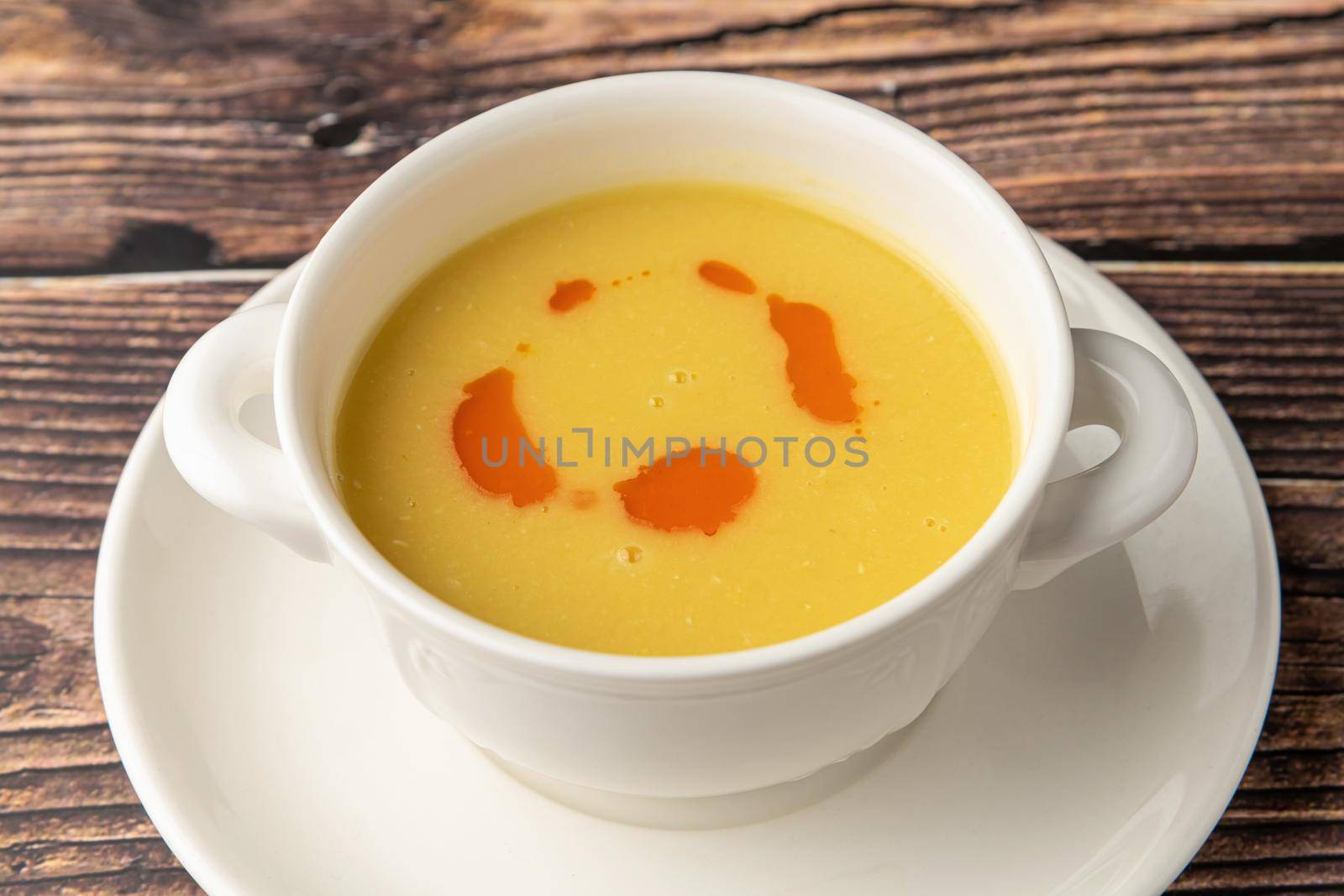 Strained lentil soup on a white porcelain plate by Sonat