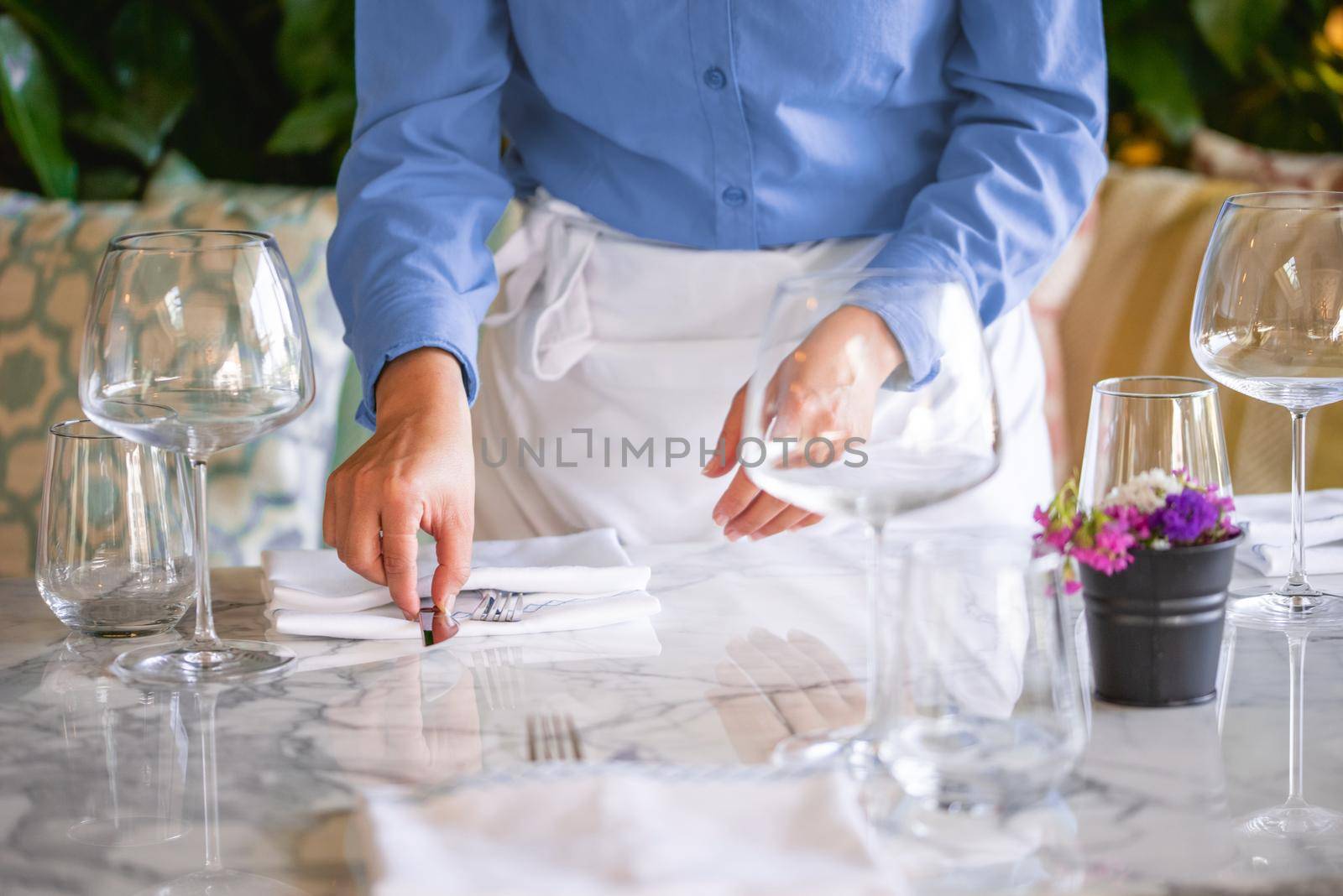 Waitress serving the empty table of the luxury restaurant by Sonat