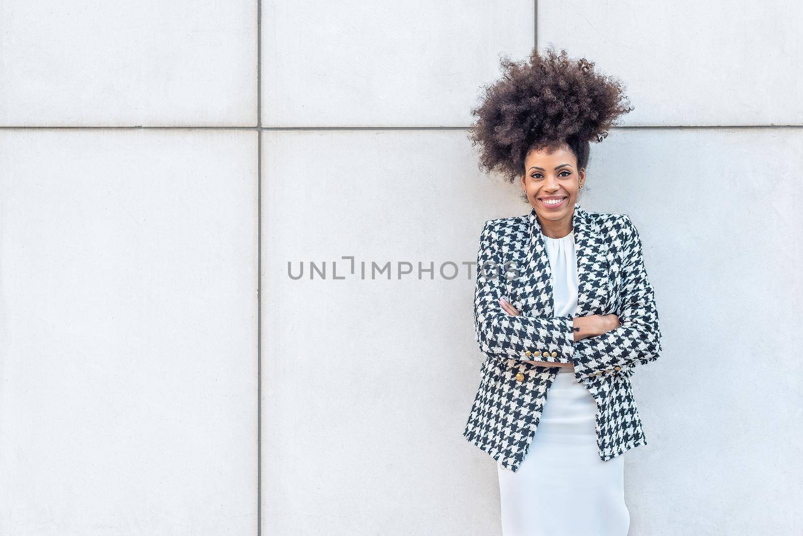 Afro-haired businesswoman posing facing the camera smiling. by ivanmoreno