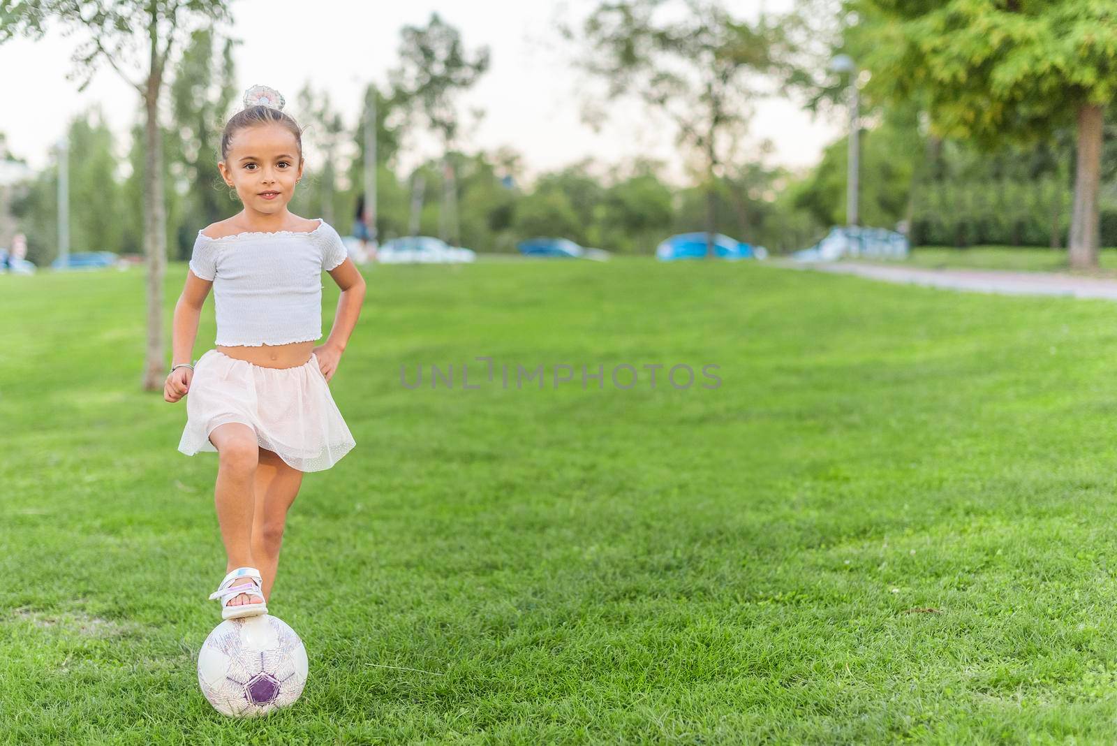 A little girl posing with soccer ball at park by ivanmoreno