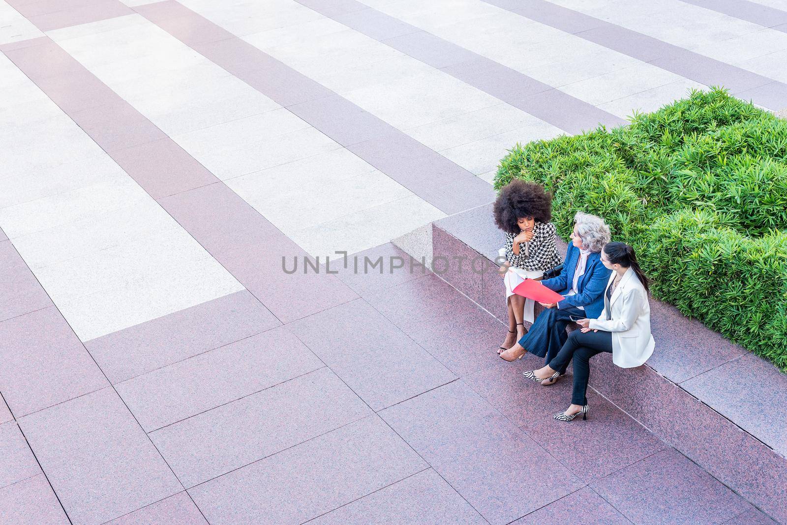 top view of businesswomen sitting and talking, pedestrian crossing in the background