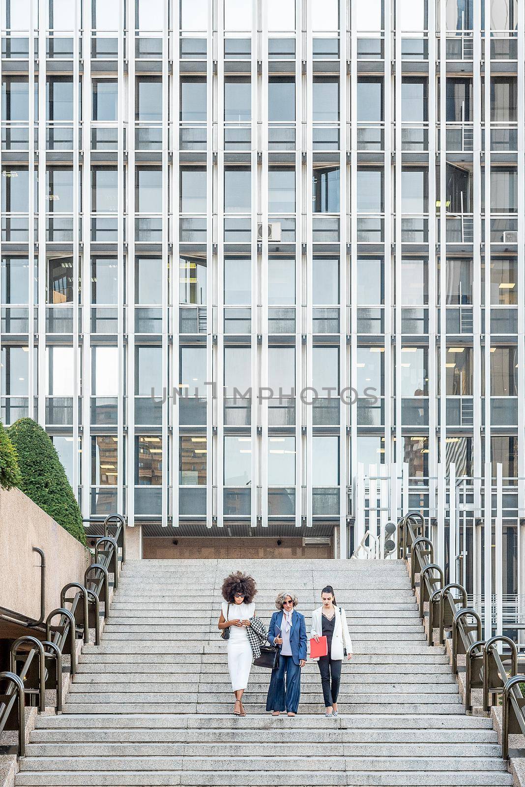 women entrepreneurs walking down the stairs after work, vertical background