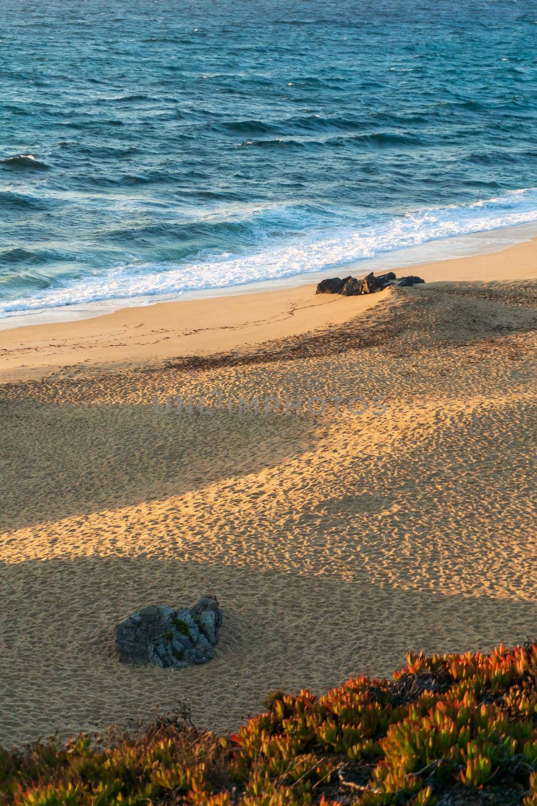 Deserted sandy beach of the atlantic ocean in the rays of the setting sun top view