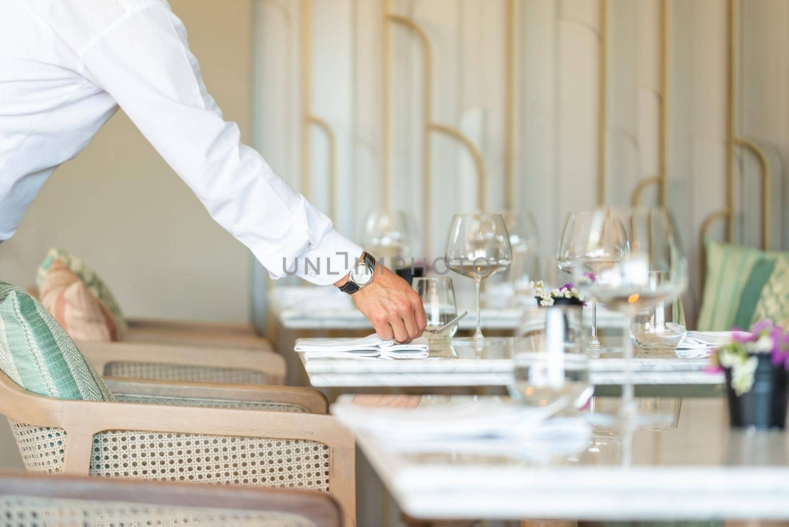 Waiter serving the empty table of the luxury restaurant by Sonat