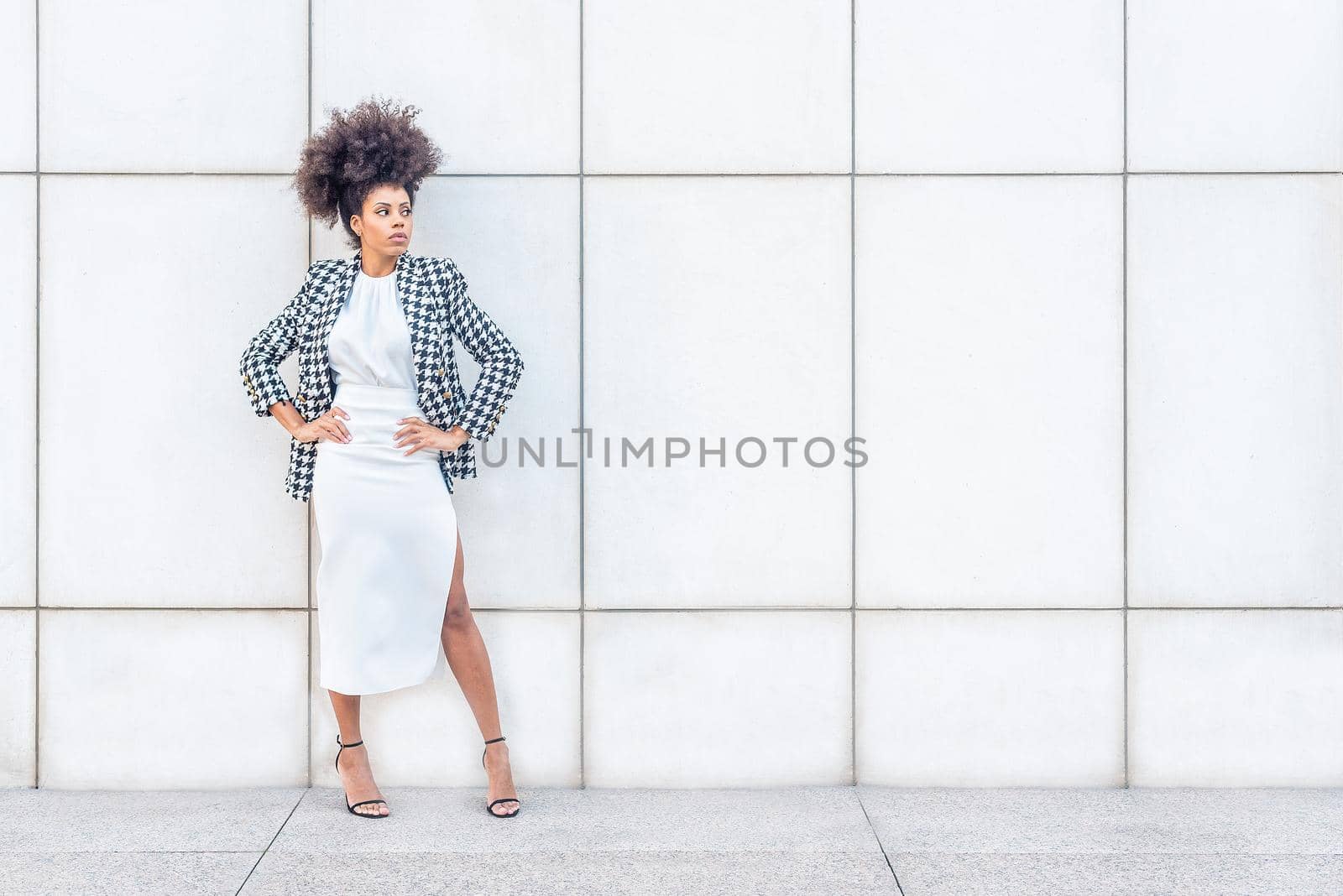 black woman in formal attire posing with her arms in jars, horizontal portrait