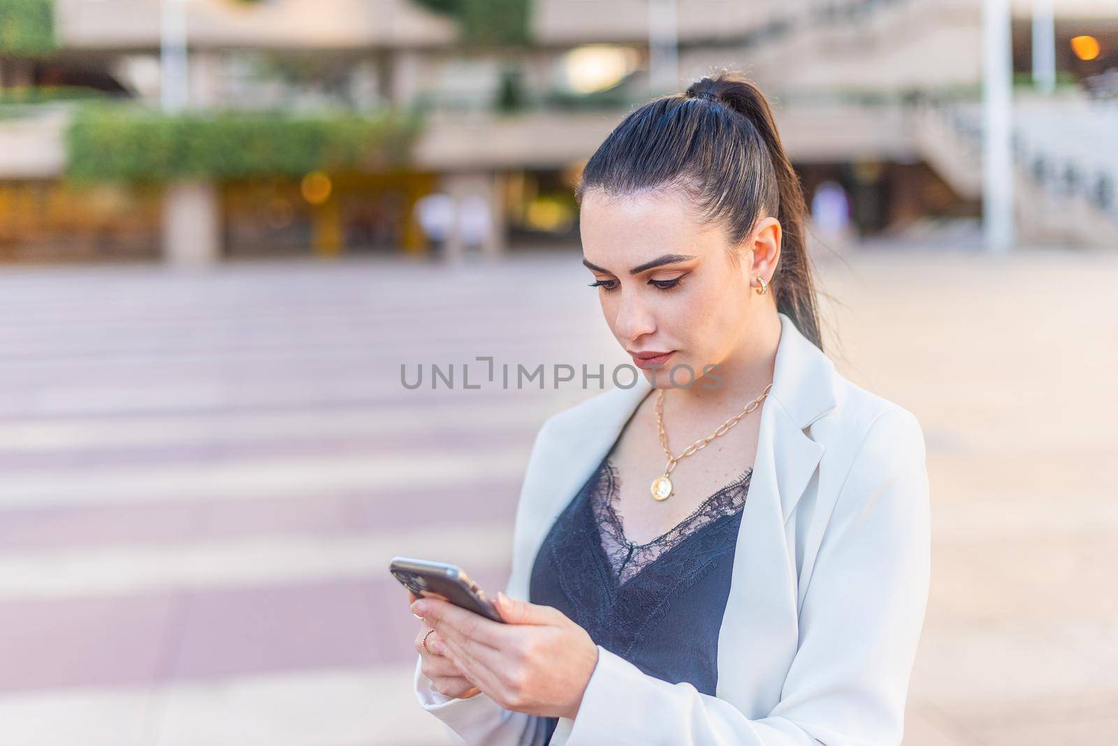 elegant woman typing on her mobile phone by ivanmoreno