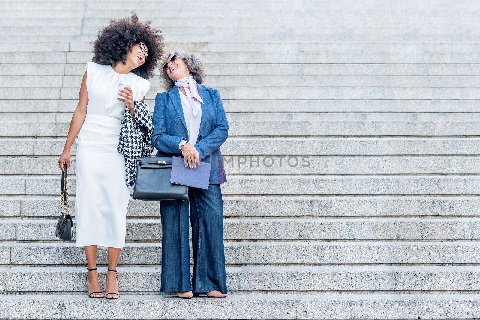 boss and worker laughing together outside the office by ivanmoreno