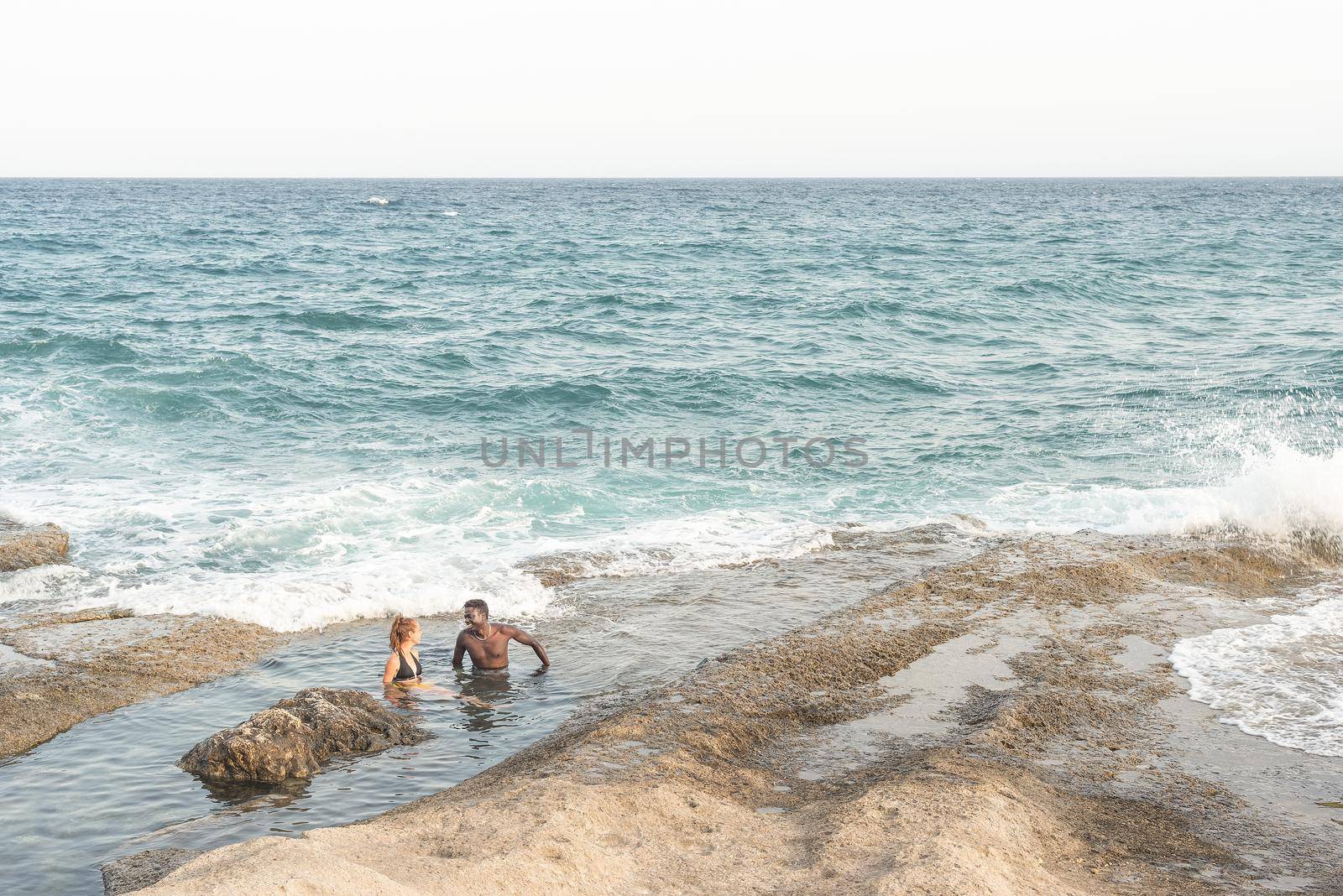 two young people bathing in the sea, from a distance by ivanmoreno