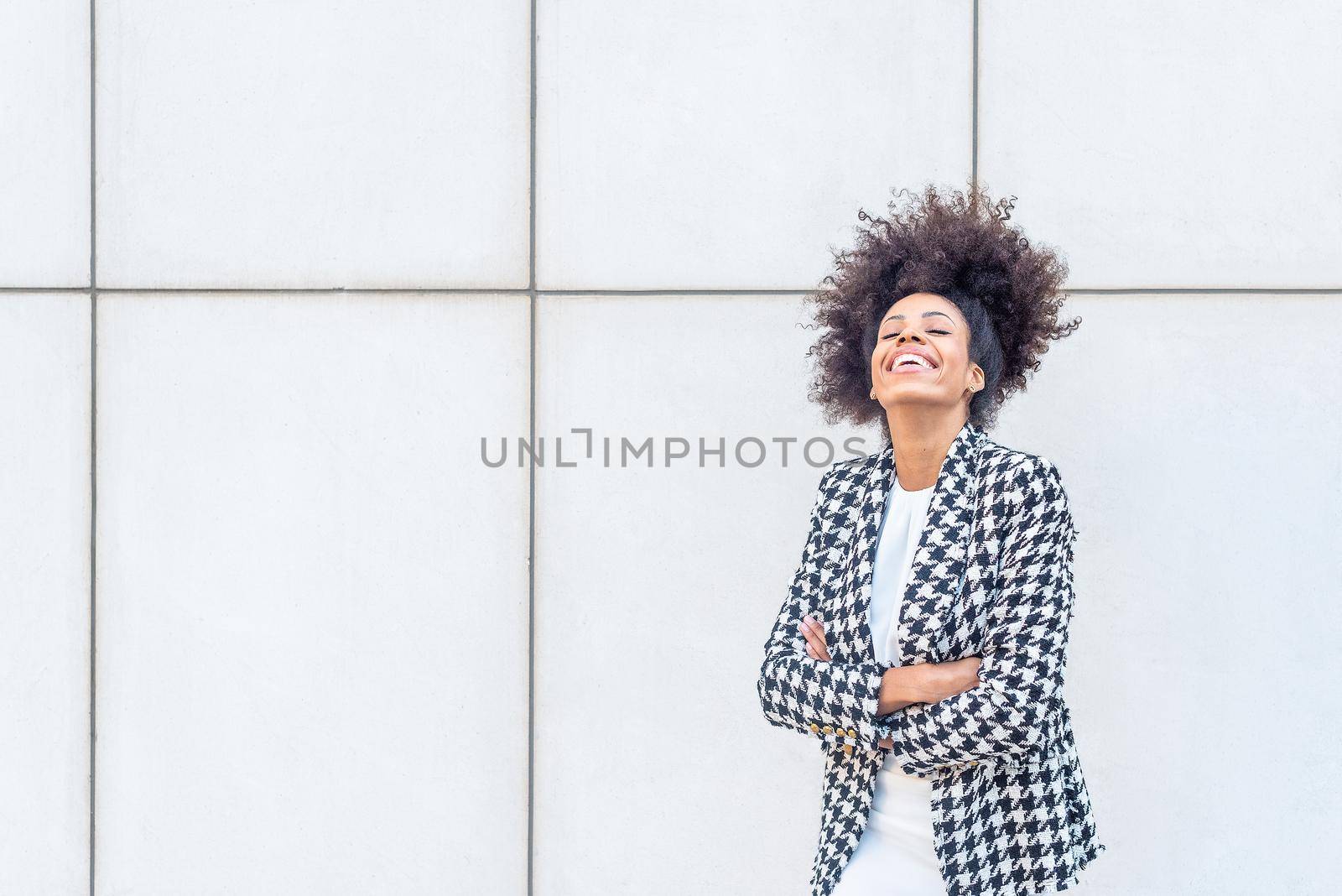 woman laughing wearing a plaid jacket and a white dress by ivanmoreno