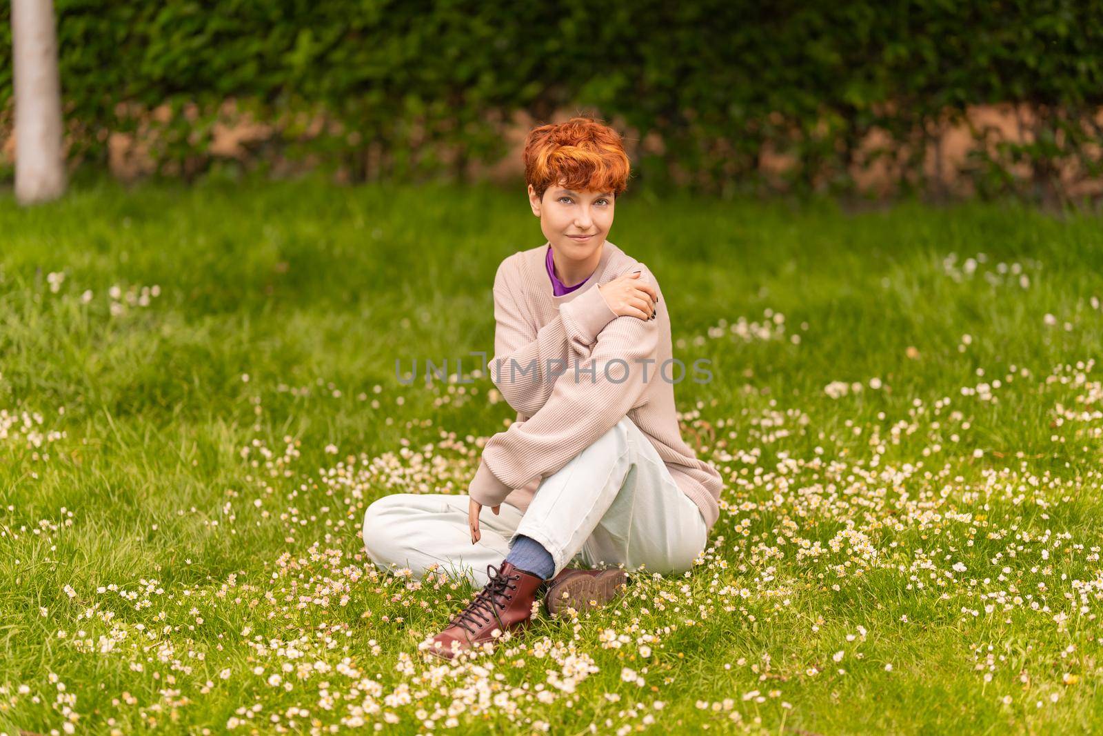 Androgynous woman resting on lawn in park by ivanmoreno