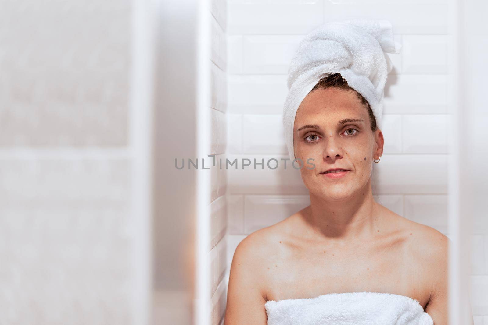 Front view of an woman after taking a shower smiling and looking at camera.