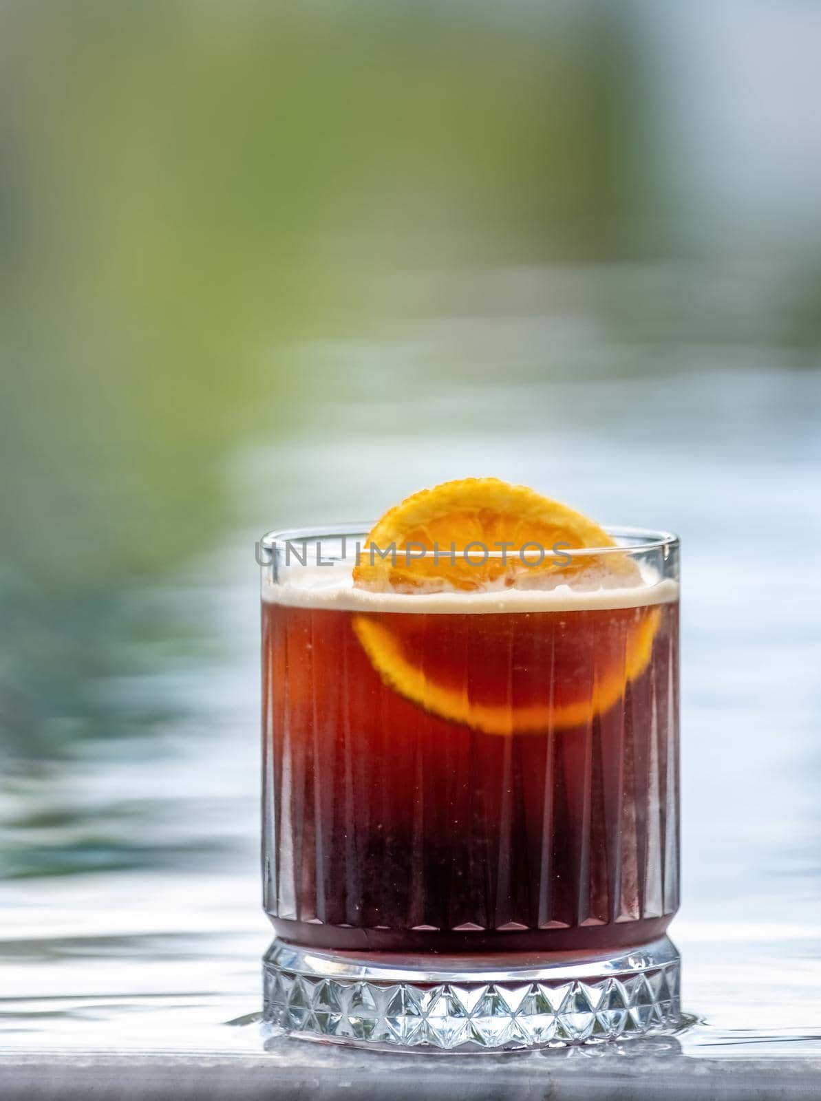 Refreshing citrus and alcoholic cocktail on blurry background