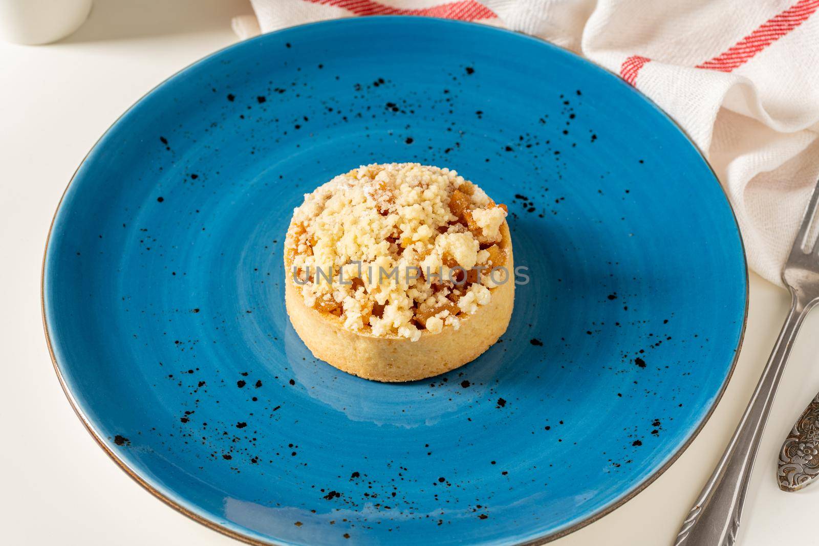 Freshly baked single portion apple pie on a blue porcelain plate by Sonat