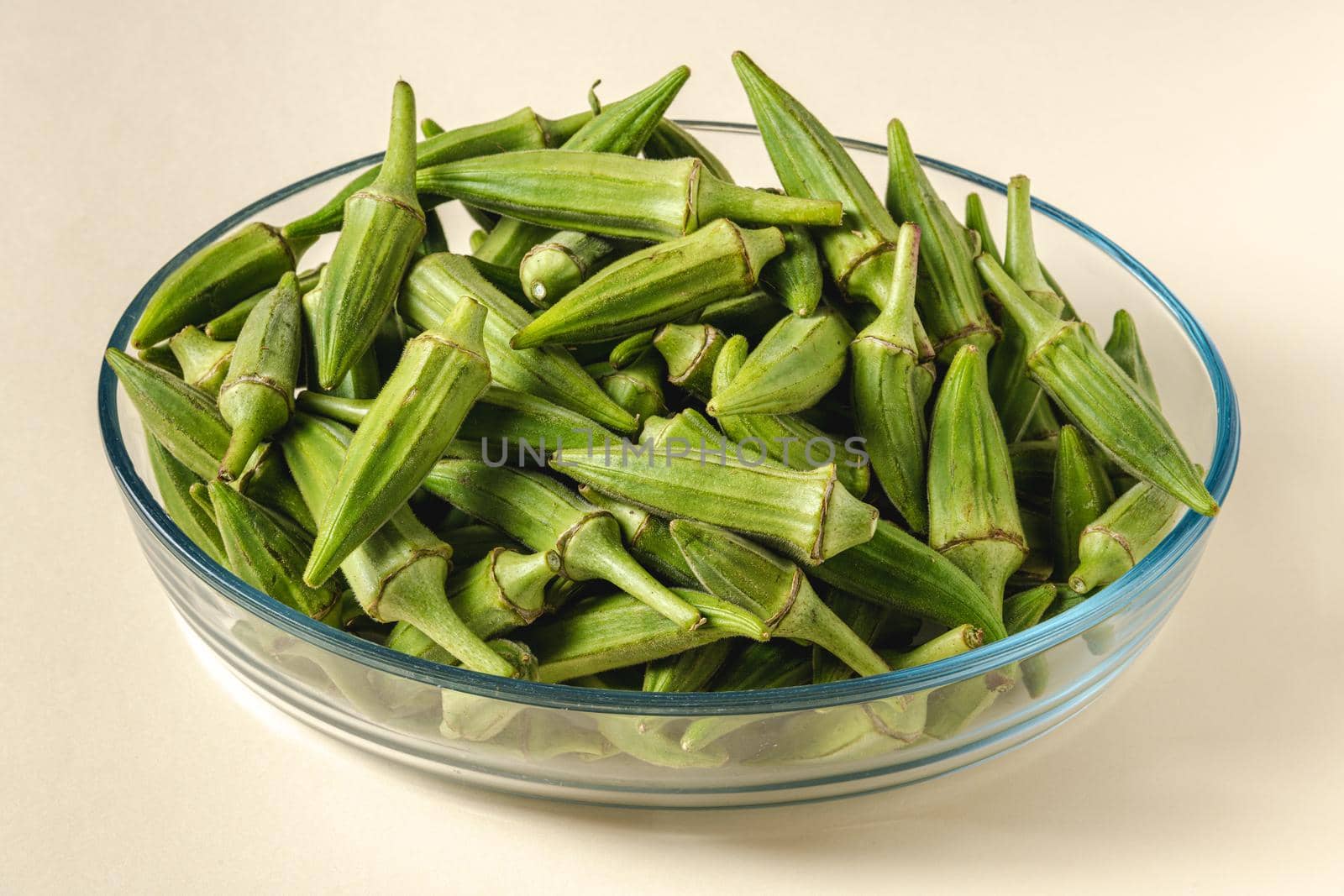 Fresh raw okra in a glass bowl. Healthy eating concept by Sonat