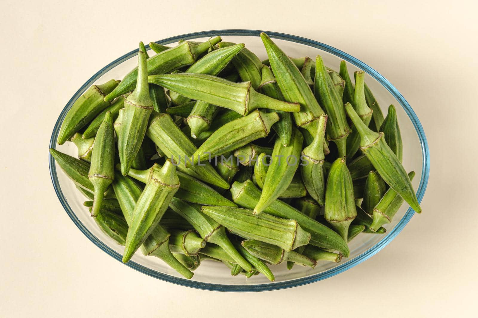 Fresh raw okra in a glass bowl. Healthy eating concept by Sonat