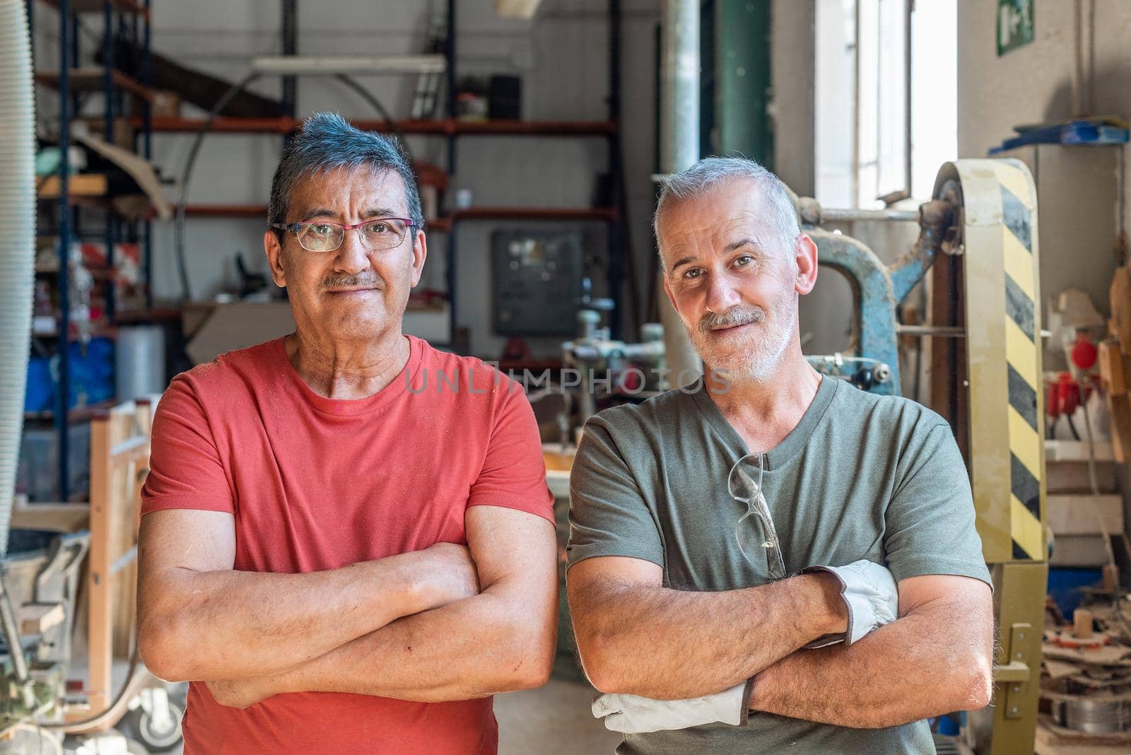 Two workers standing looking forward with folded arms, horizontal background