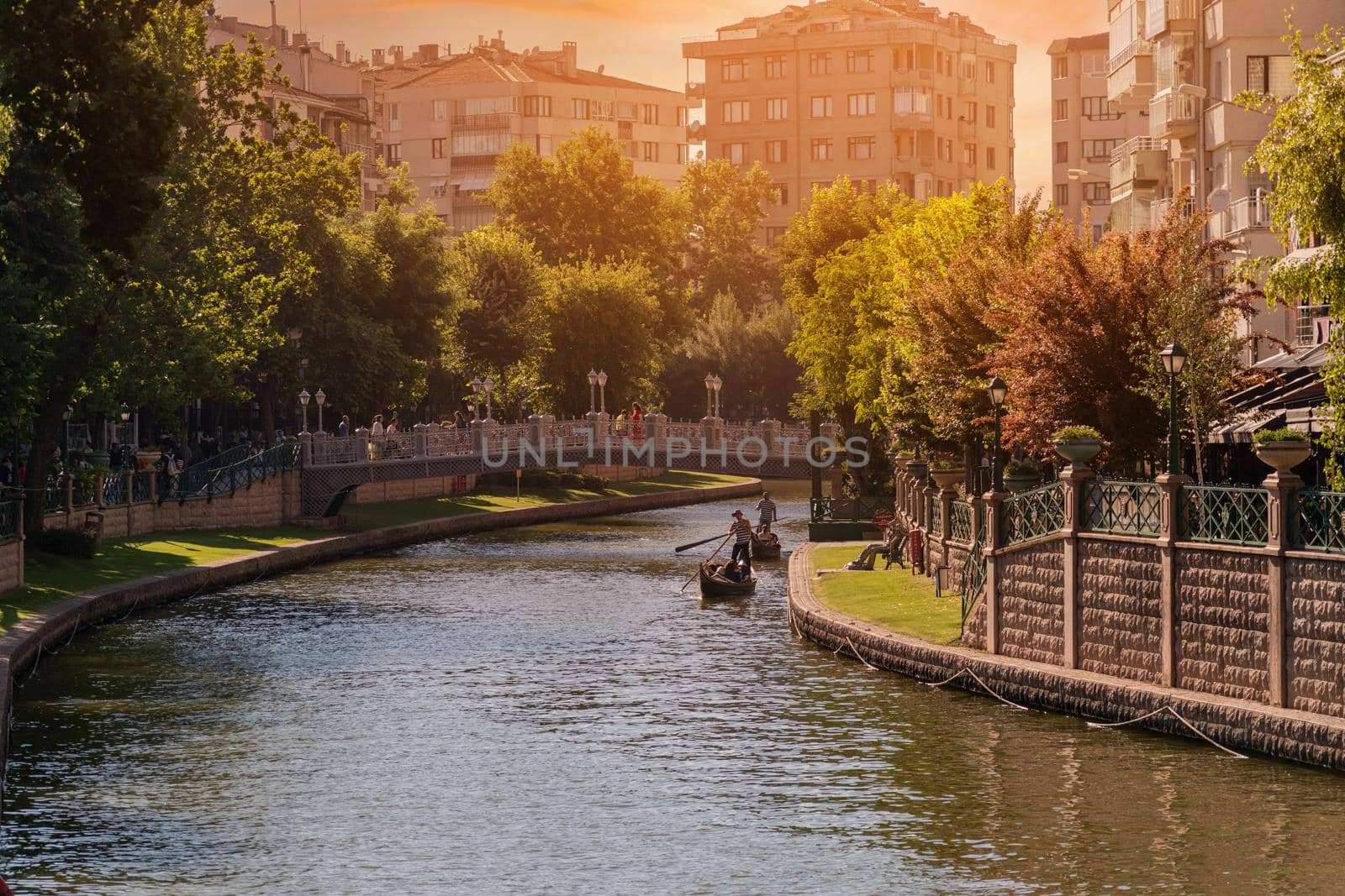 Antalya, Turkey - July 5, 2022: Touristic boat and gondola on the Porsuk River passing through the city center of Eskisehir