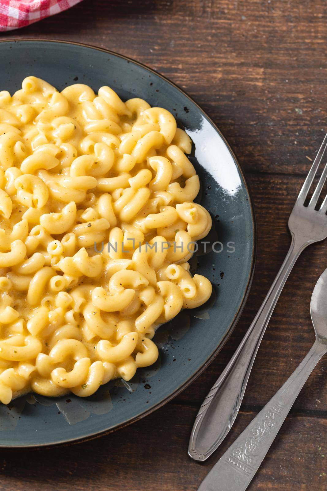 Delicious Mac n Cheese or macaroni and cheese on a black porcelain plate by Sonat