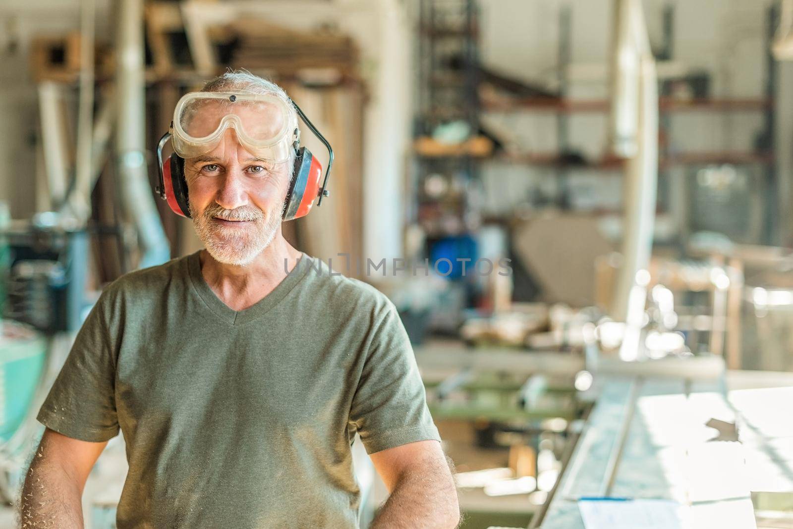 Worker smiling in the factory with the safety work equipment, blurred background