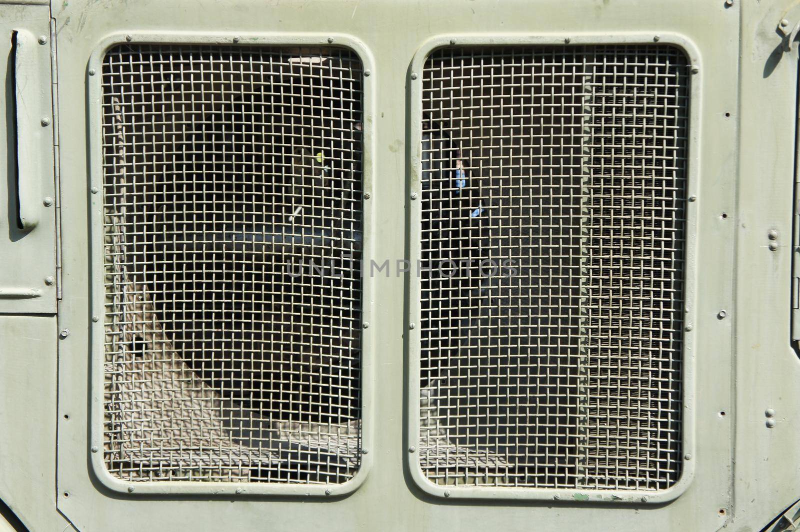 Lattice texture close up. Holes of grey metal plate with round regular holes texture background. Military Texture. Lattice construction on military vehicles in green protective colors