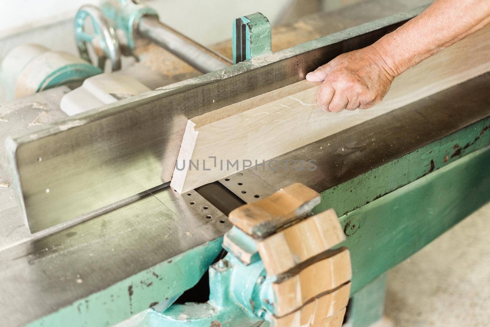 Person working with a wood planing machine, horizontal foreground