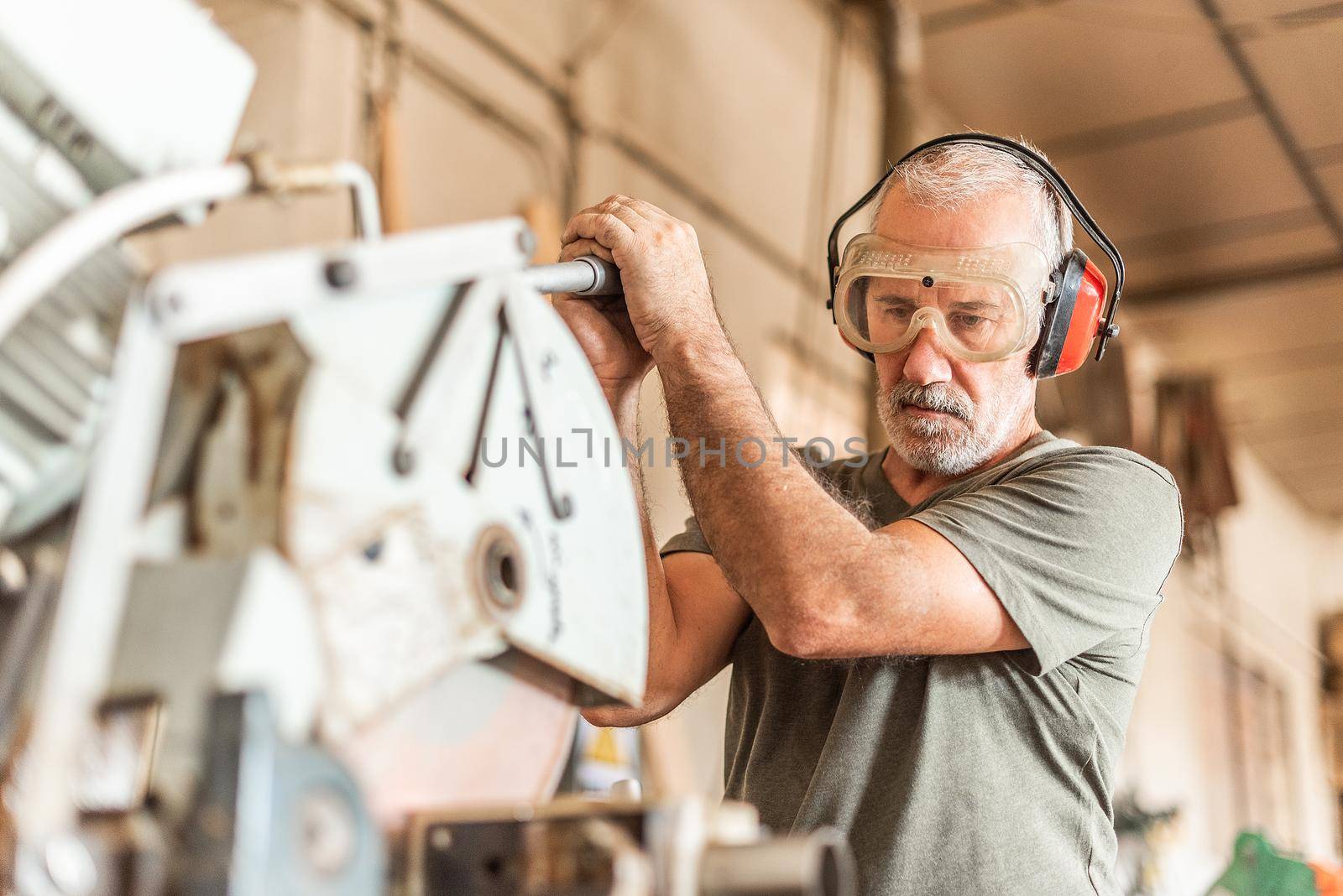 Man cutting a stainless tube using a safety equipment, blurred foreground
