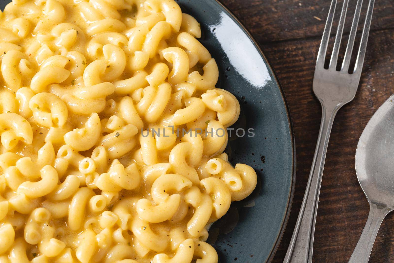 Delicious Mac n Cheese or macaroni and cheese on a black porcelain plate by Sonat