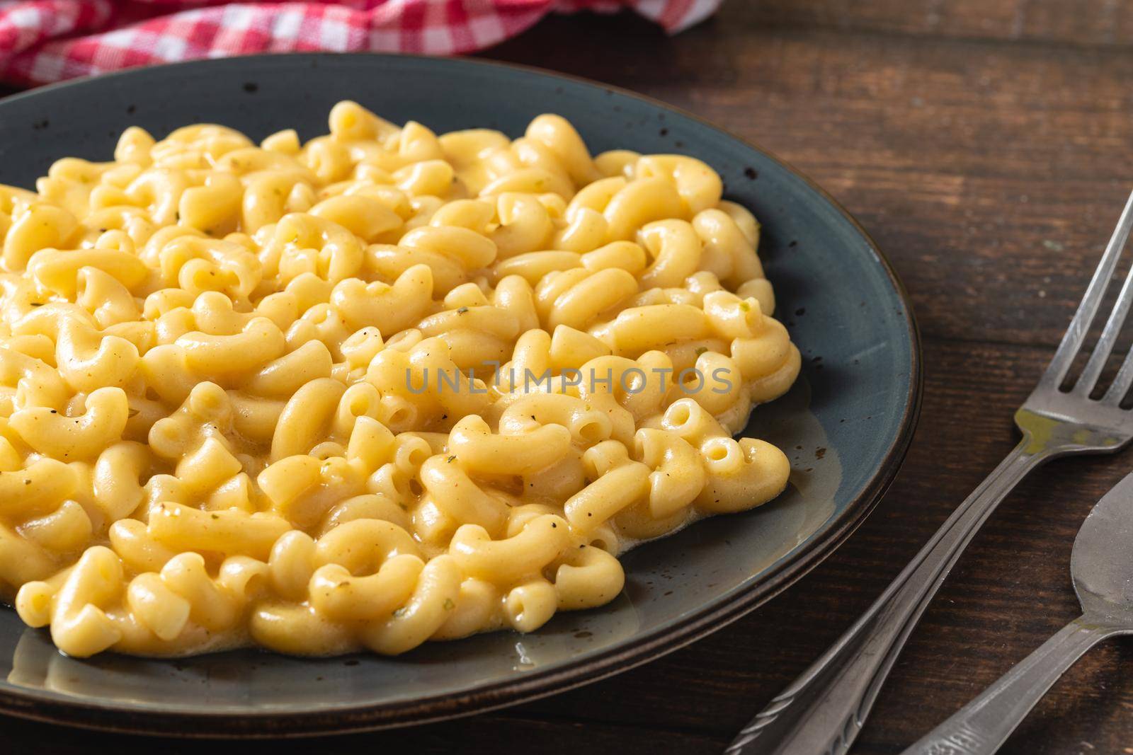 Delicious Mac n Cheese or macaroni and cheese on a black porcelain plate by Sonat